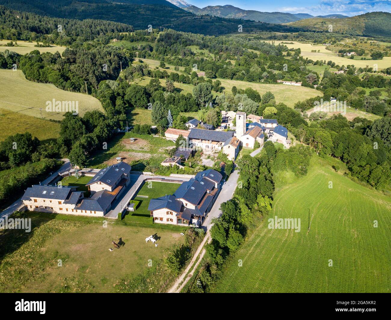 Vue aérienne de l'église de Santa Eugènia de Nerellà à Bellver de Cerdanya Alp Pirineu Lleida province de Catalogne Espagne. Parmi les maisons traditionnelles dans Banque D'Images