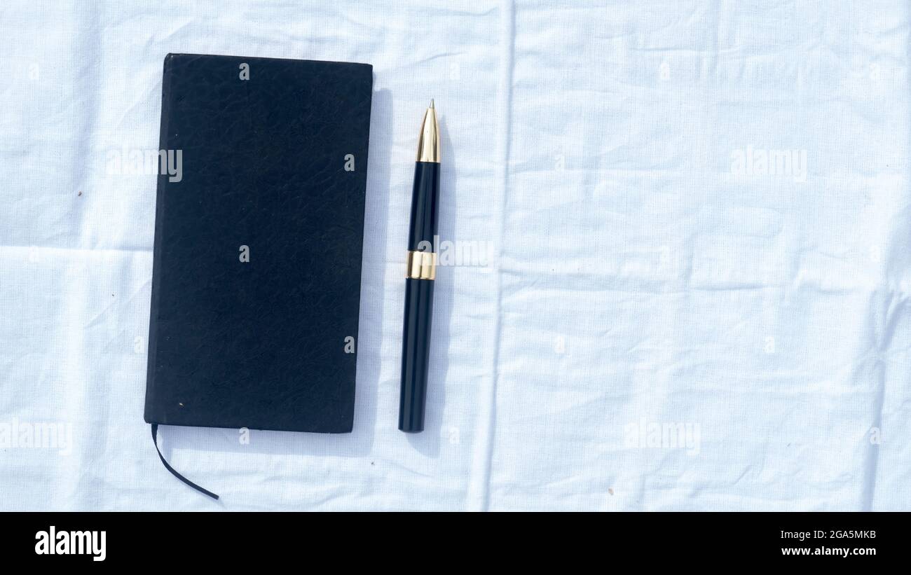 Un carnet et un stylo sur un chiffon blanc en coton. Vue sur les ange. Formation professionnelle. Copier l'espace pour le texte sur le côté droit. Banque D'Images