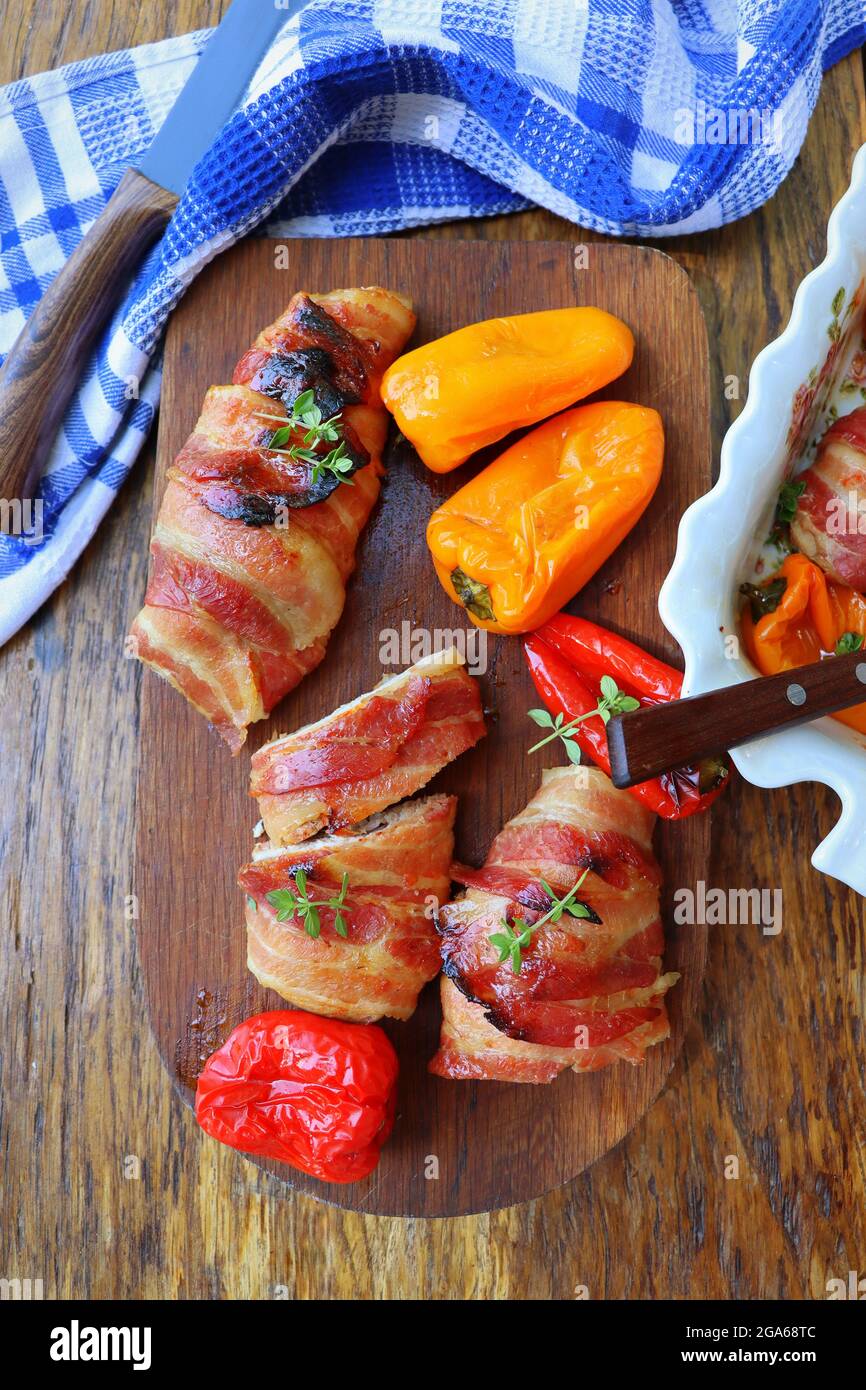 Arrière-plan du dîner.Blanc de poulet grillé enveloppé de bacon dans une poêle sur une table rustique en bois.Vue de dessus Banque D'Images
