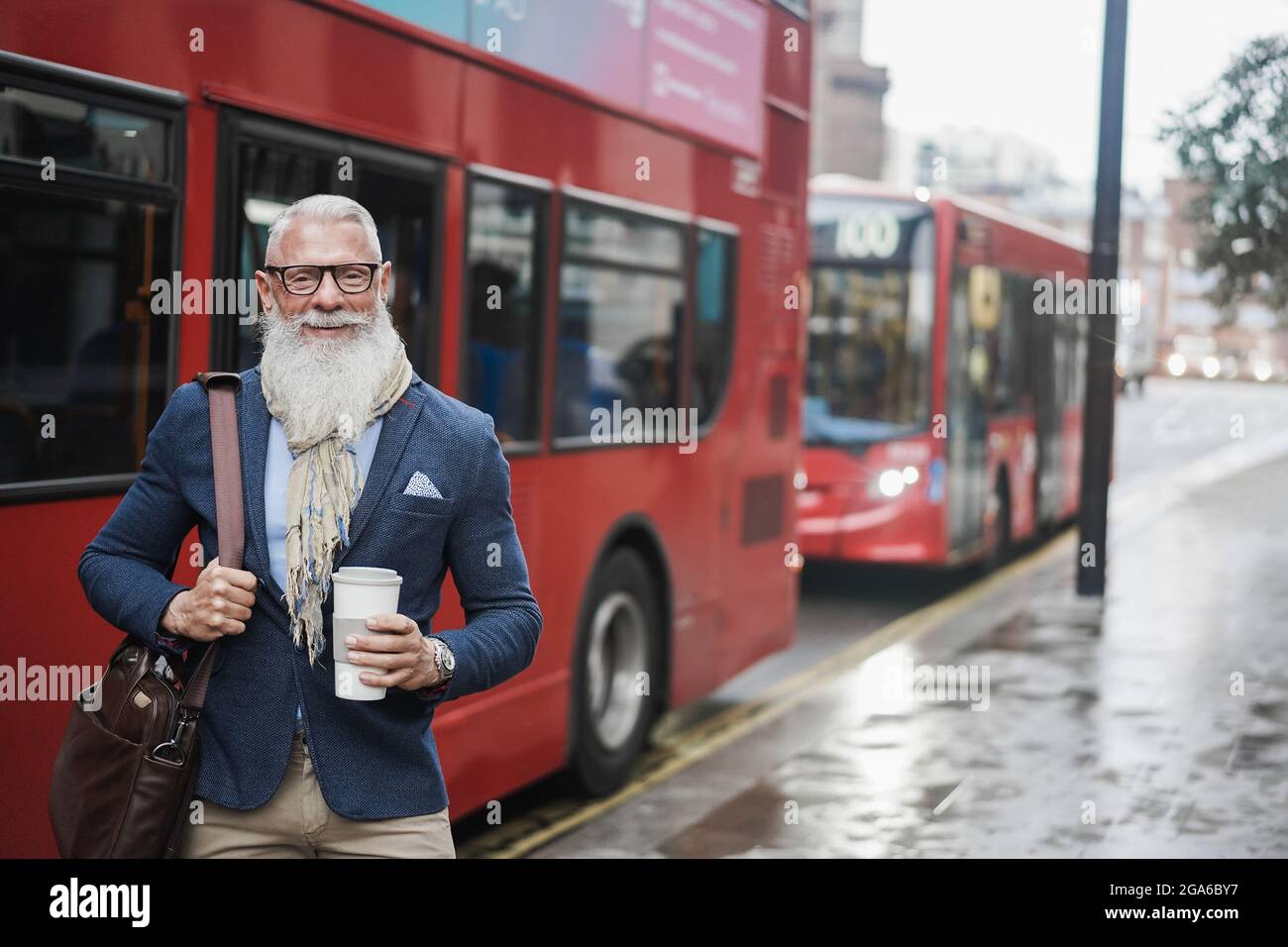 Homme d'affaires senior qui va travailler à boire du café avec la gare routière de londres en arrière-plan - Focus on face Banque D'Images