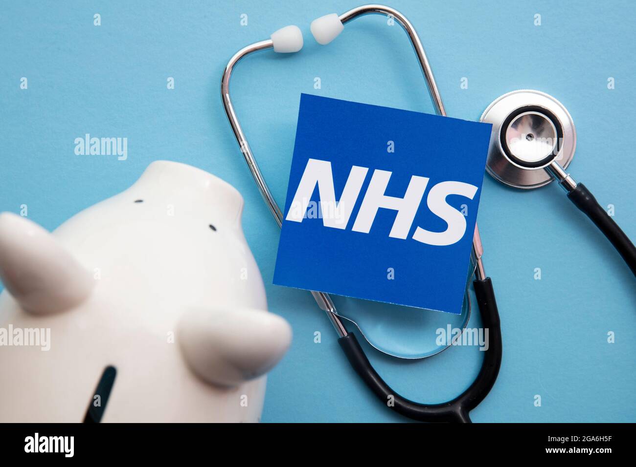 LONDRES, Royaume-Uni - juillet 2021 : logo du NHS National Health Service avec une banque de cochon d'épargne Banque D'Images