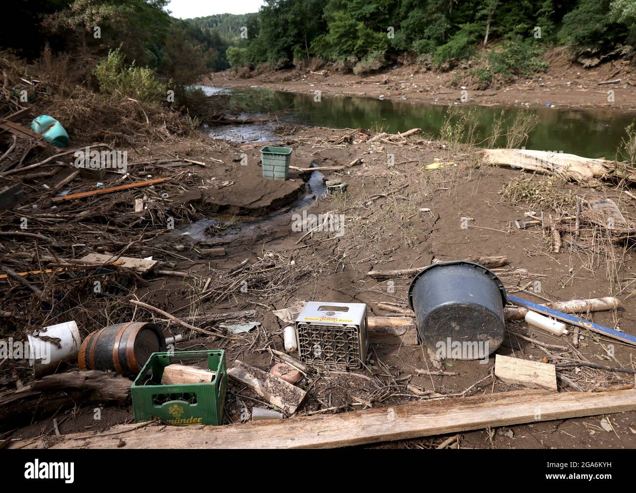 29 juillet 2021, Rhénanie-du-Nord-Westphalie, Gemünd: Les articles ménagers lavés, y compris un seau, des caisses à bière et un baril en bois, se trouvent sur la rive d'une branche du lac Urft dans le parc national d'Eifel. La région a été gravement touchée par la catastrophe des inondations. L'Association de l'eau Eifel-Rur (WVER) procède actuellement à des essais de résidus éventuels dans l'eau du réservoir Urft. Photo: Oliver Berg/dpa Banque D'Images