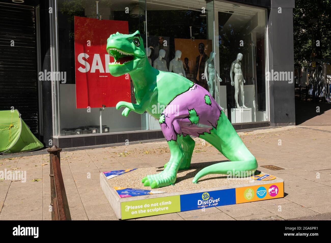 Numéro 8 Dinosaur Hulkasaurus peint en vert avec des shorts violets debout sur une plinthe du centre-ville de Haymarket Norwich. Banque D'Images