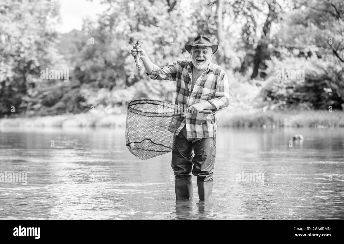 La vie commence à la retraite. Week-end d'été. Pêcheur avec canne à pêche. Pêcheur à la retraite barbu. Pêche au gros gibier. Activité sportive et passe-temps. Appât à la truite Banque D'Images