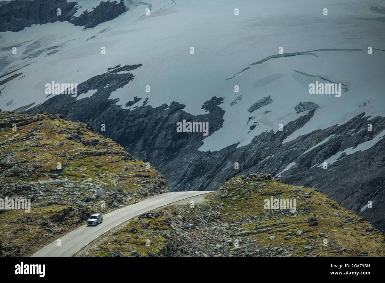Voiture compacte sur la spectaculaire route des Alpes norvégiennes avec des glaciers près de Geiranger, Vestland. Banque D'Images