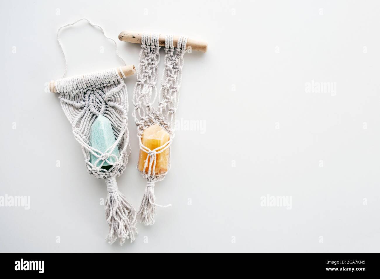 Pendentifs hippie macrame avec pierres gemmes comme talismans spirituels sur un fond blanc avec espace vide. Banque D'Images
