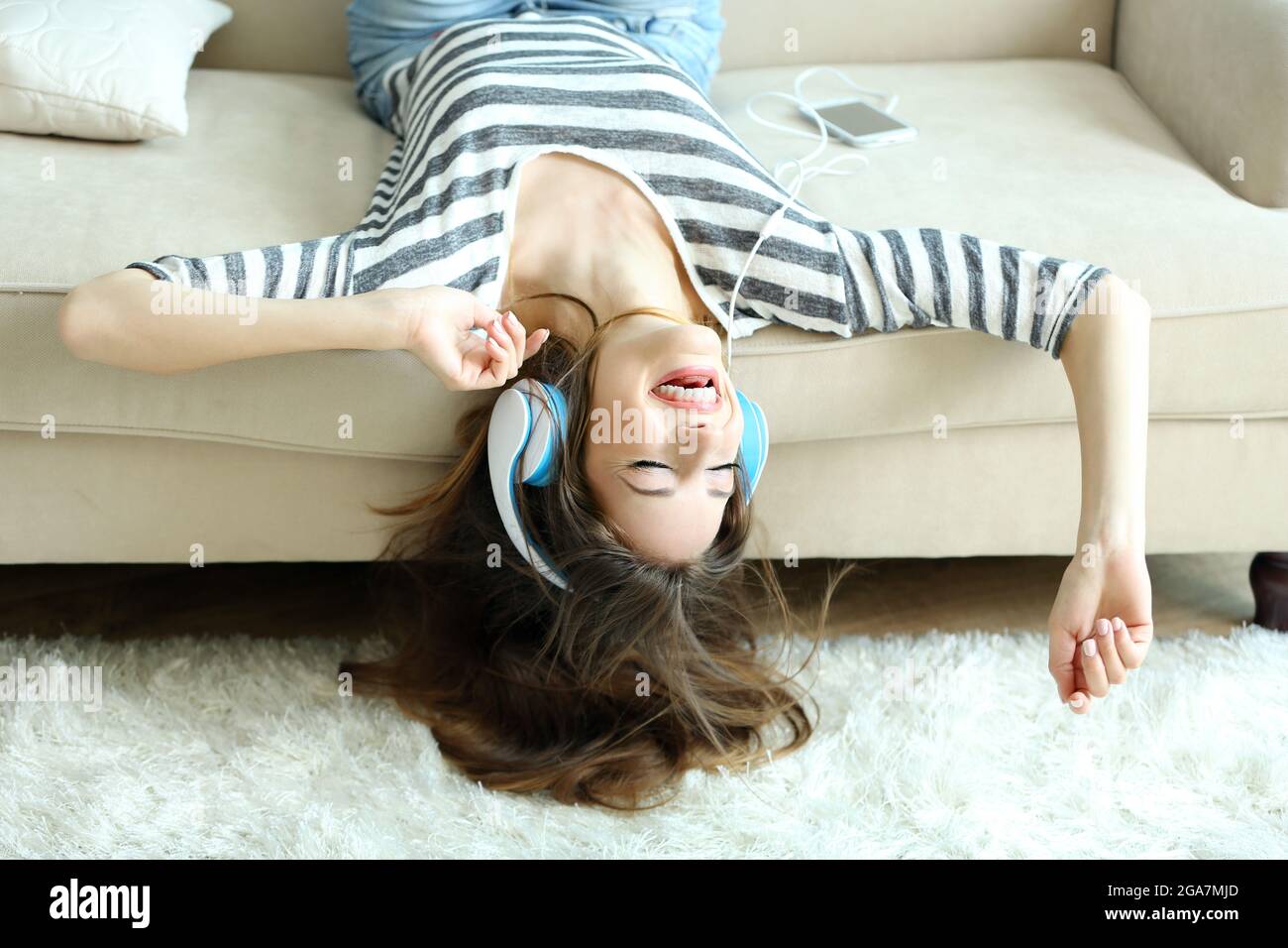 Lécoute Au Casque De La Musique Femme Couchée Sur Un Canapé Dans La Salle à Manger Photo Stock 