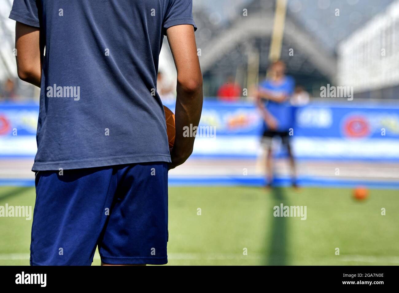 Garçons jouant à un jeu de ballon en plein air pendant un camp sportif d'été, à Milan. Banque D'Images