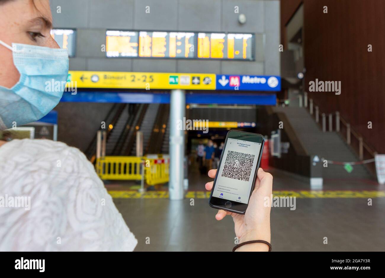 Rome, Italie, jeudi 29 juillet 2021. Certificat Covid numérique européen passe verte sur smartphone devant les horaires des trains Banque D'Images