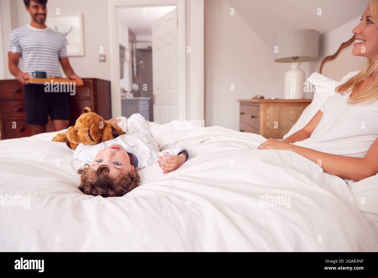 Père et fils mère surprenante avec petit déjeuner au lit à la maison Banque D'Images