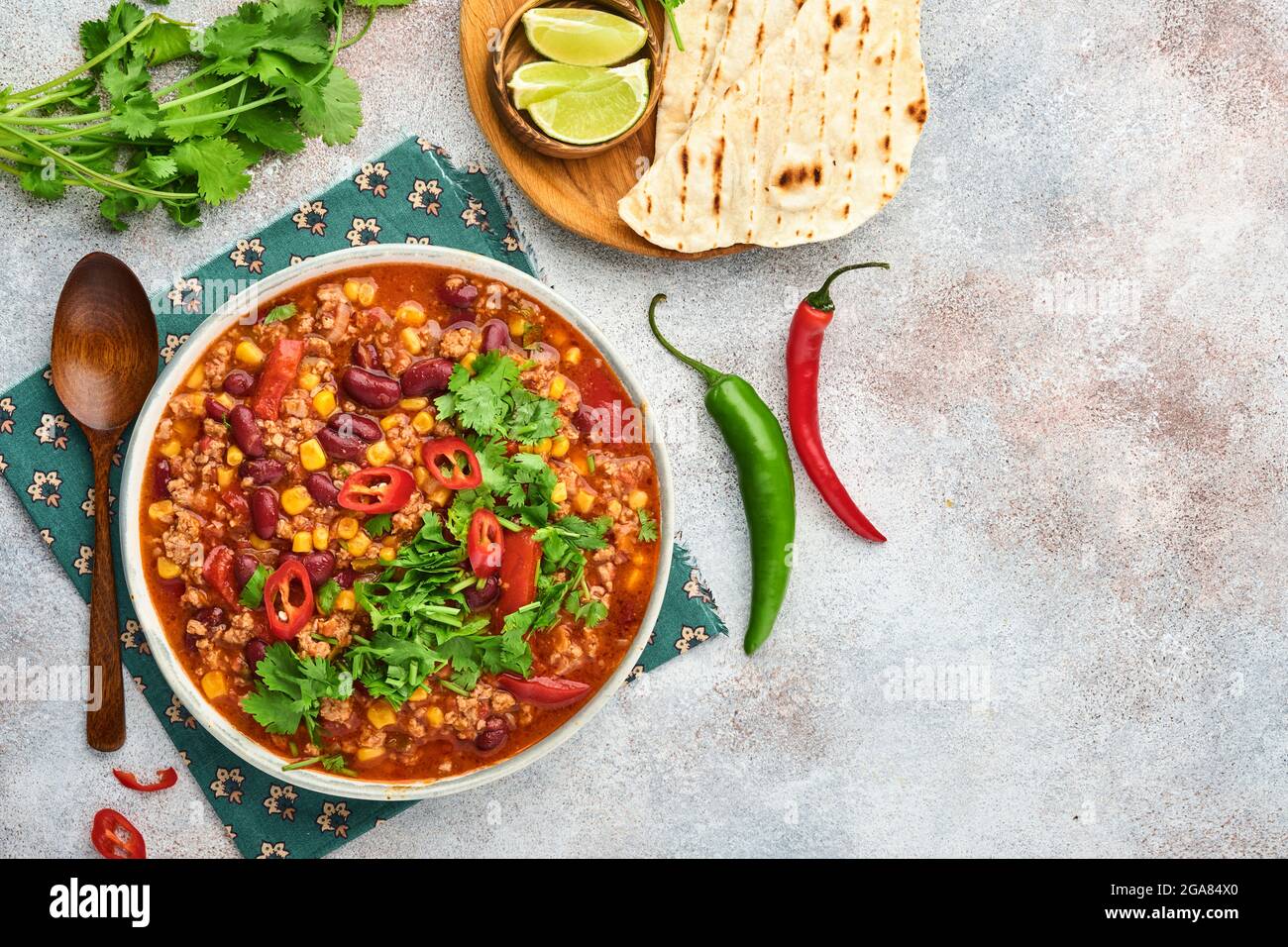 Soupe mexicaine de haricots noirs avec viande hachée, tomate, coriandre, avocat et légumes ragoût sur fond gris clair ardoise, pierre ou béton. Tradition Banque D'Images