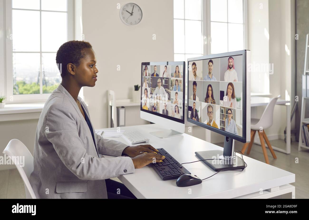 Femme d'affaires utilisant plusieurs ordinateurs pendant la formation du personnel virtuel et les réunions de travail Banque D'Images