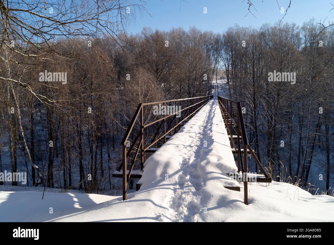 Le paysage avec pont à travers ravin en bois. La nature en hiver durée sur fond bleu ciel Banque D'Images