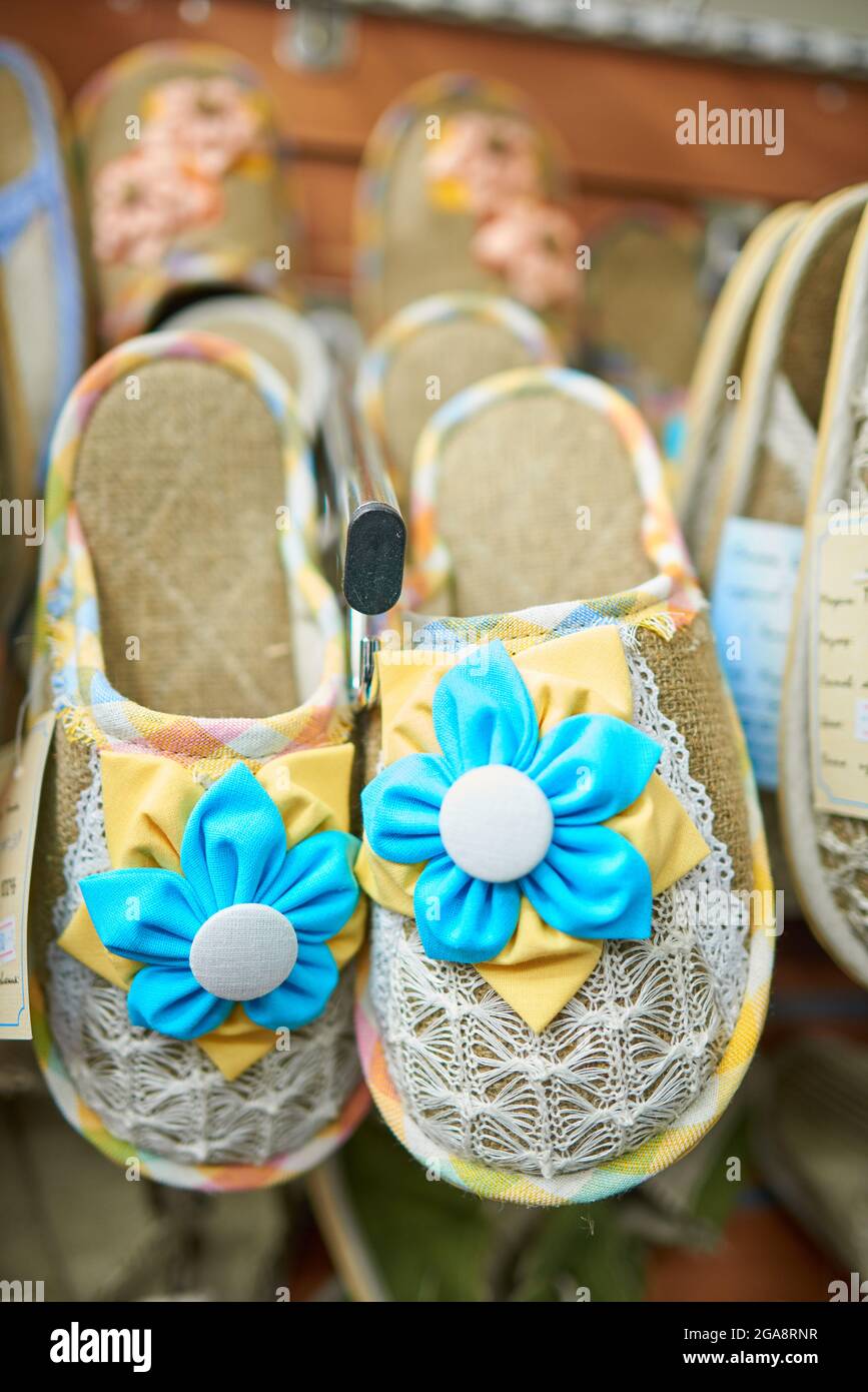 Chaussons à la maison décorés de fleurs en tissu bleu et jaune et de tissus tricotés blancs Banque D'Images