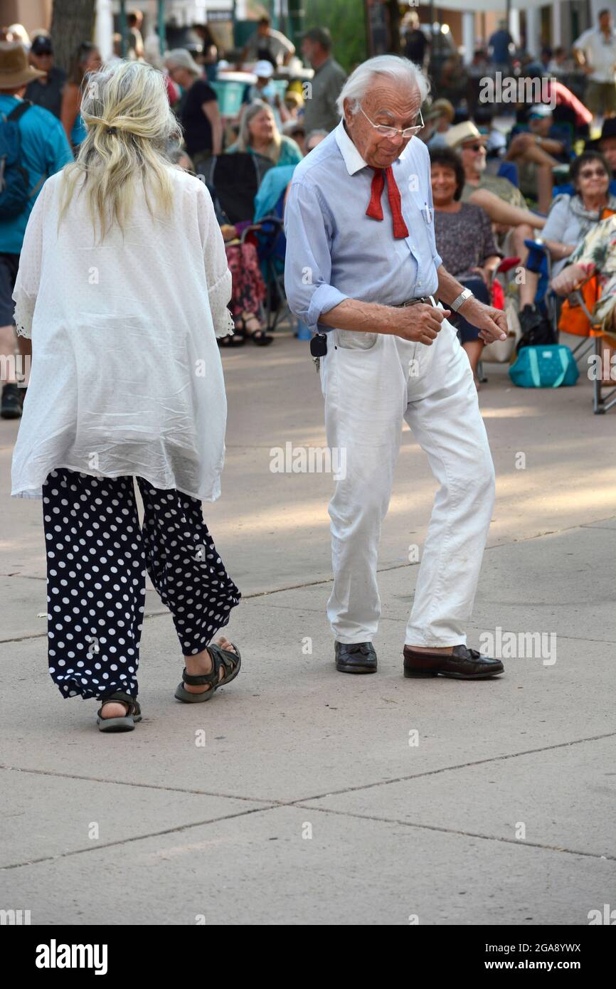 Les gens de tous âges aiment danser sur la musique d'un groupe de musiciens qui se présente sur la place historique de Santa Fe, Nouveau-Mexique. Banque D'Images