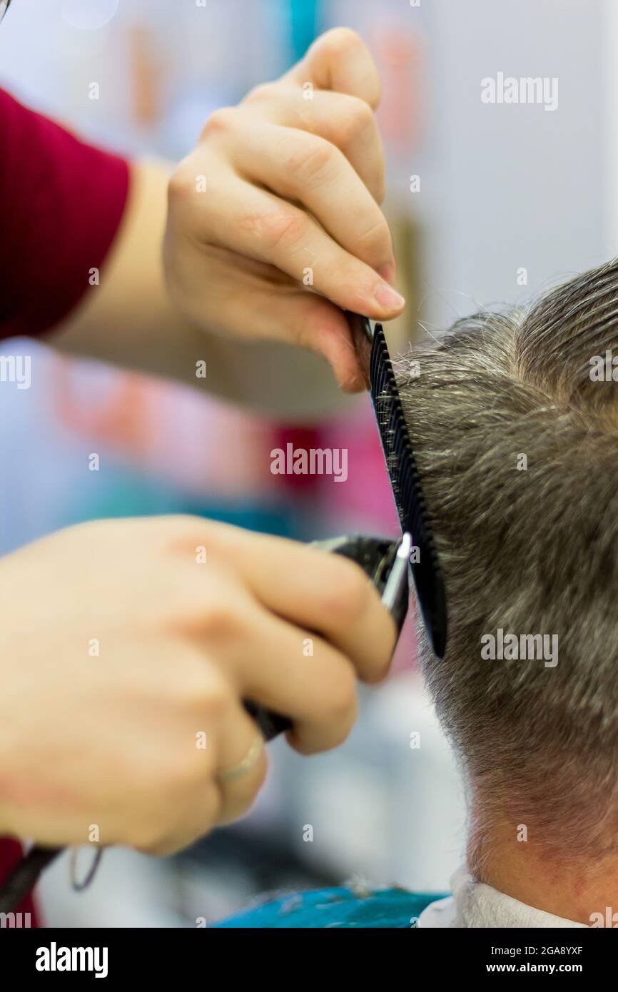Le coiffeur coupe les cheveux de l'homme à l'aide d'une tondeuse et d'un  peigne. Coupe courte pour hommes. Gros plan Photo Stock - Alamy