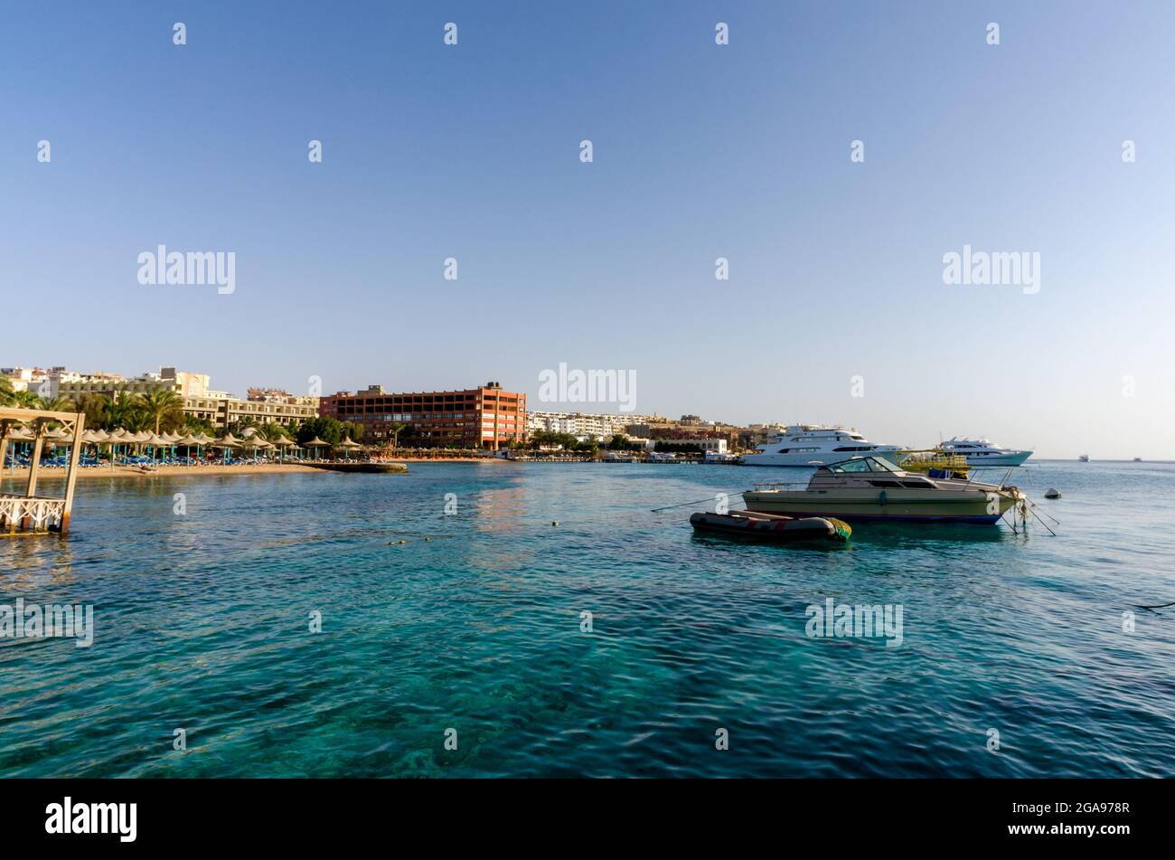 parasols de plage et palmiers sur le fond de la mer rouge et des navires en egypte hurghada Banque D'Images