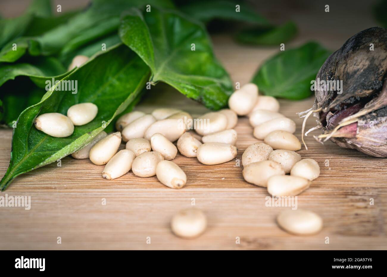 Pignons sur une table en bois avec basilic et ail Banque D'Images