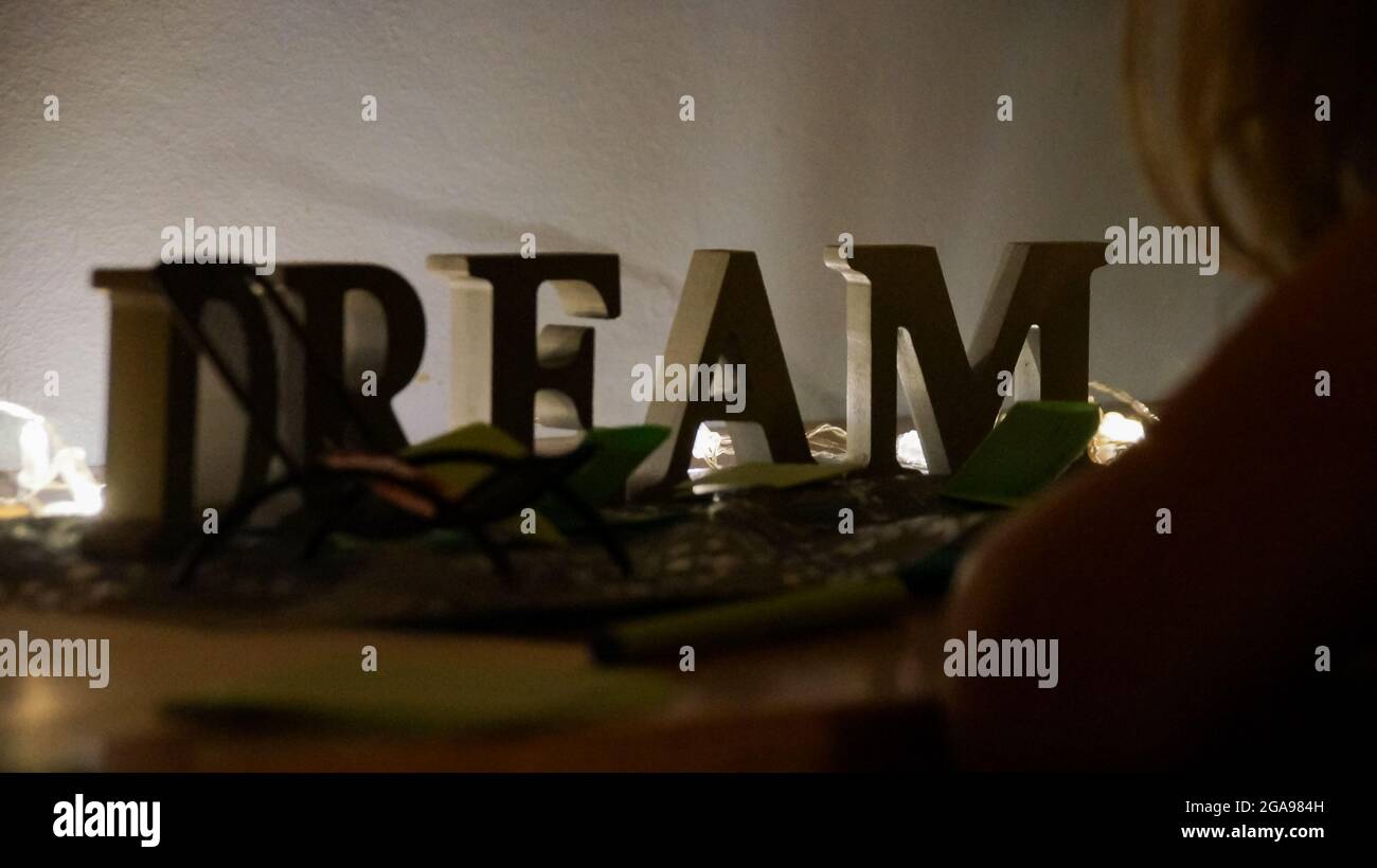 Des lettres en bois qui s'épelent RÊVENT sur une table éclairée Banque D'Images