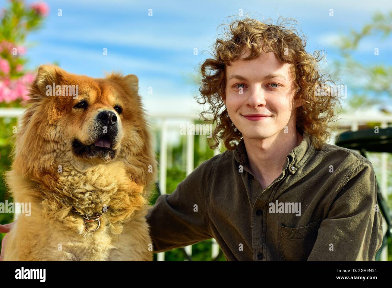 Portrait d'un jeune homme avec un chien de race Chow Chow Banque D'Images