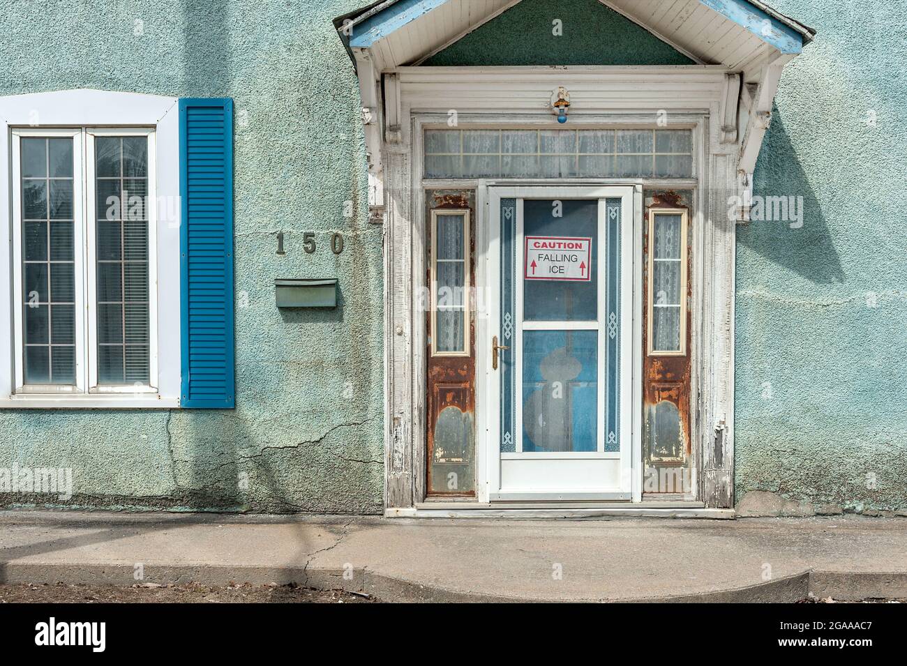 Porte bleue et volets bleus sur le mur en stuc vert à 150 n'importe quelle rue. Banque D'Images