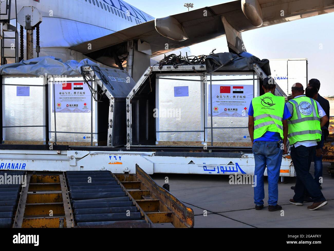 Damas, Syrie. 29 juillet 2021. Les membres du personnel déchargent les vaccins chinois COVID-19 à l'aéroport international de Damas, en Syrie, le 29 juillet 2021. Jeudi, le ministère syrien de la Santé a reçu un lot de vaccins chinois COVID-19 fournis par la Société chinoise de la Croix-Rouge. Crédit: Ammar Safarjalani/Xinhua/Alamy Live News Banque D'Images