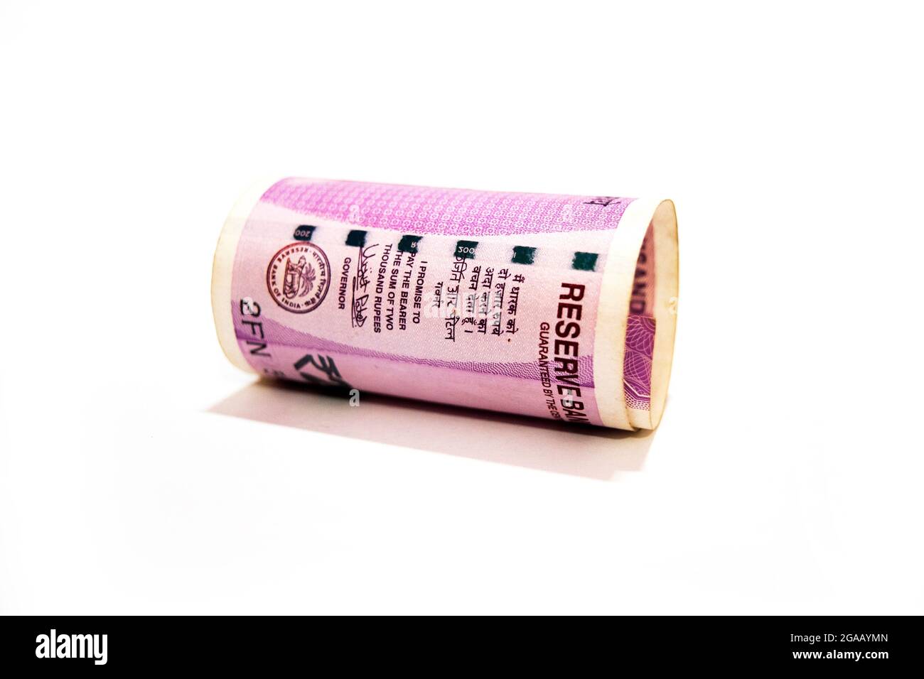 Indienne deux mille roupies ont roulé jusqu'à un billet de banque isolé sur fond blanc. Banque D'Images
