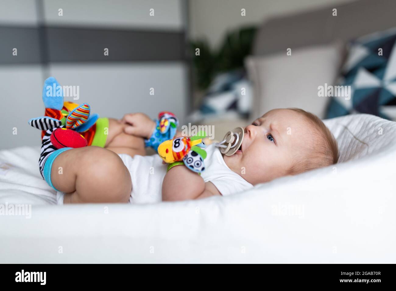 Mignon Blanc Blanc Bebe De Trois Mois Couche Dans Le Cocon A La Maison Enfant Portant Sur Les Mains Et Les Jambes Bourre Son Jouet Educatif Sucer Mamelon Photo Stock Alamy