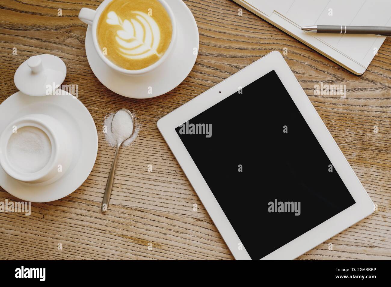 Vue de dessus d'une tasse de café avec organiseur et tablette numérique sur la table. Banque D'Images