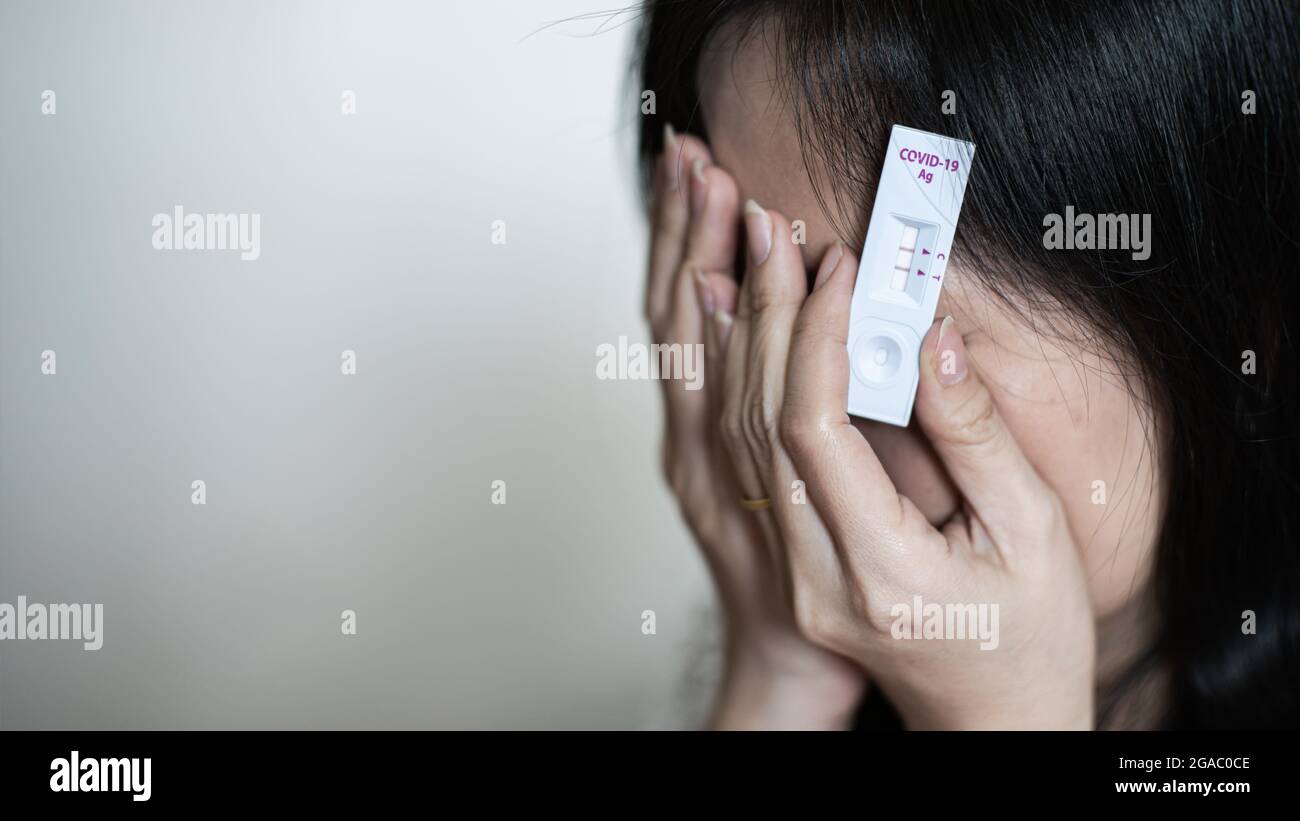 La femme pleure avec le stress après que ses résultats de test ont montré positif. Elle a été infectée par le covid-19 Banque D'Images