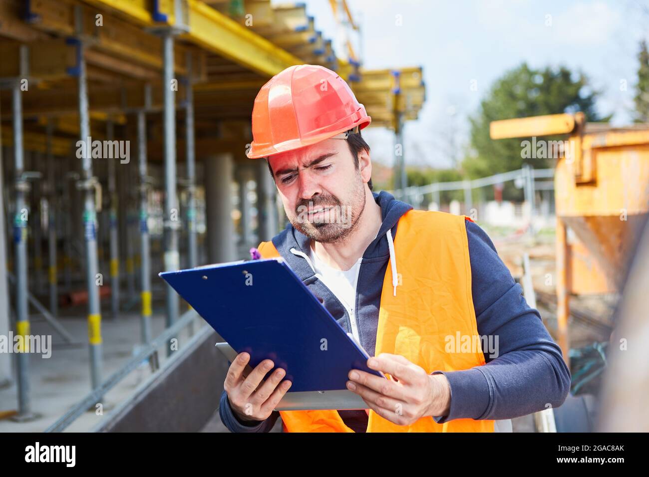Architecte ou contremaître avec un rapport de test sur le planchette à pince sur le site du bâtiment dans le shell Banque D'Images