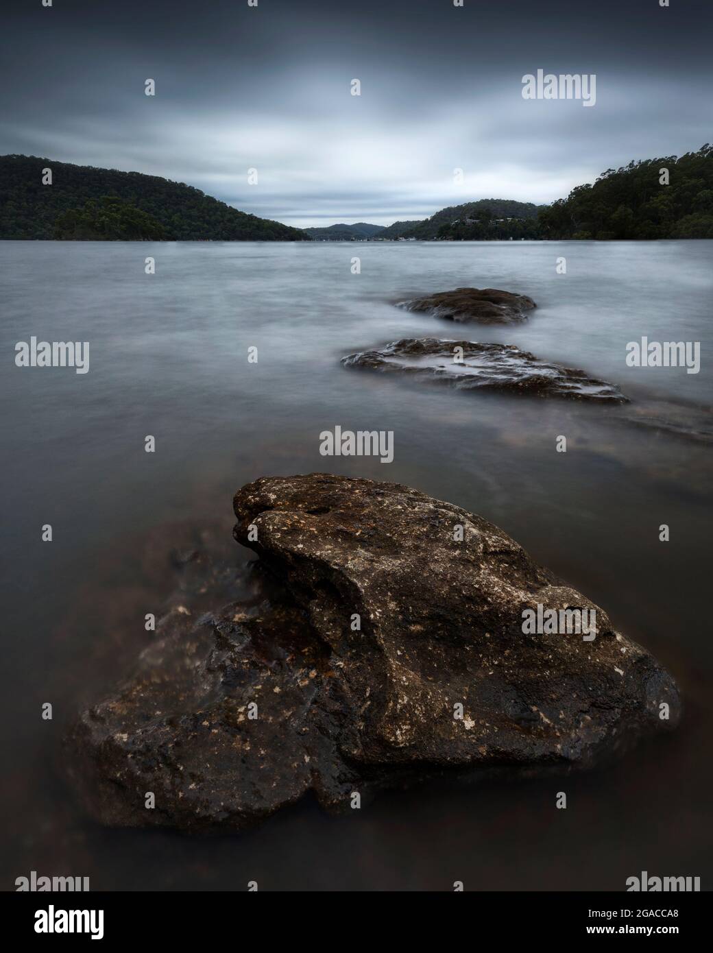 rochers dans un grand plan d'eau entouré de montagnes Banque D'Images