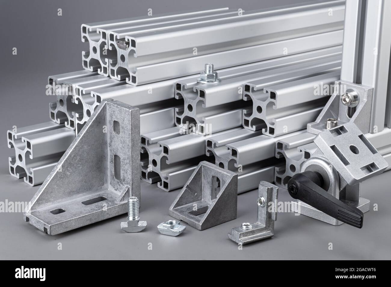 Barres profilés en aluminium avec angle d'angle et vis sur fond gris. Ingénierie de l'industrie de la construction et concept de matériau. Banque D'Images