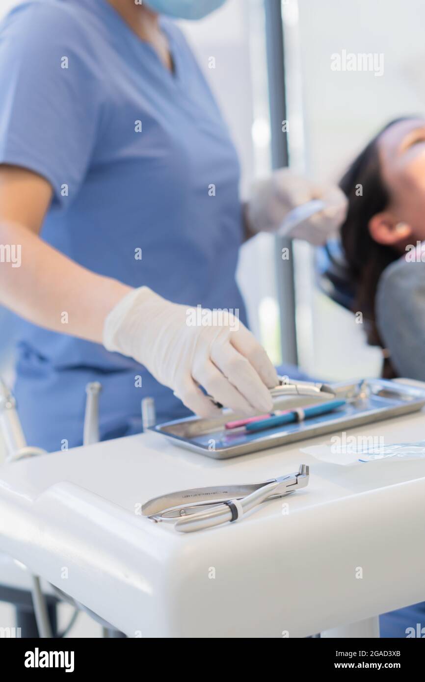 Mains d'un médecin à la clinique dentaire avec tous les ustensiles  nécessaires pour les procédures dentaires Photo Stock - Alamy