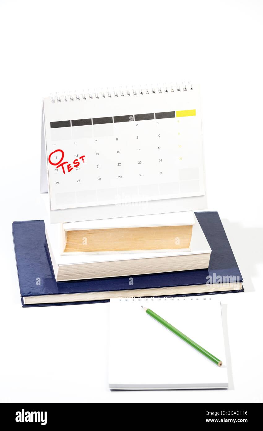 Apprentissage du concept de test avec Mark sur le calendrier - cercle rouge marquant la date de l'examen sur la feuille de calendrier au-dessus des livres et bloc-notes avec crayon Banque D'Images