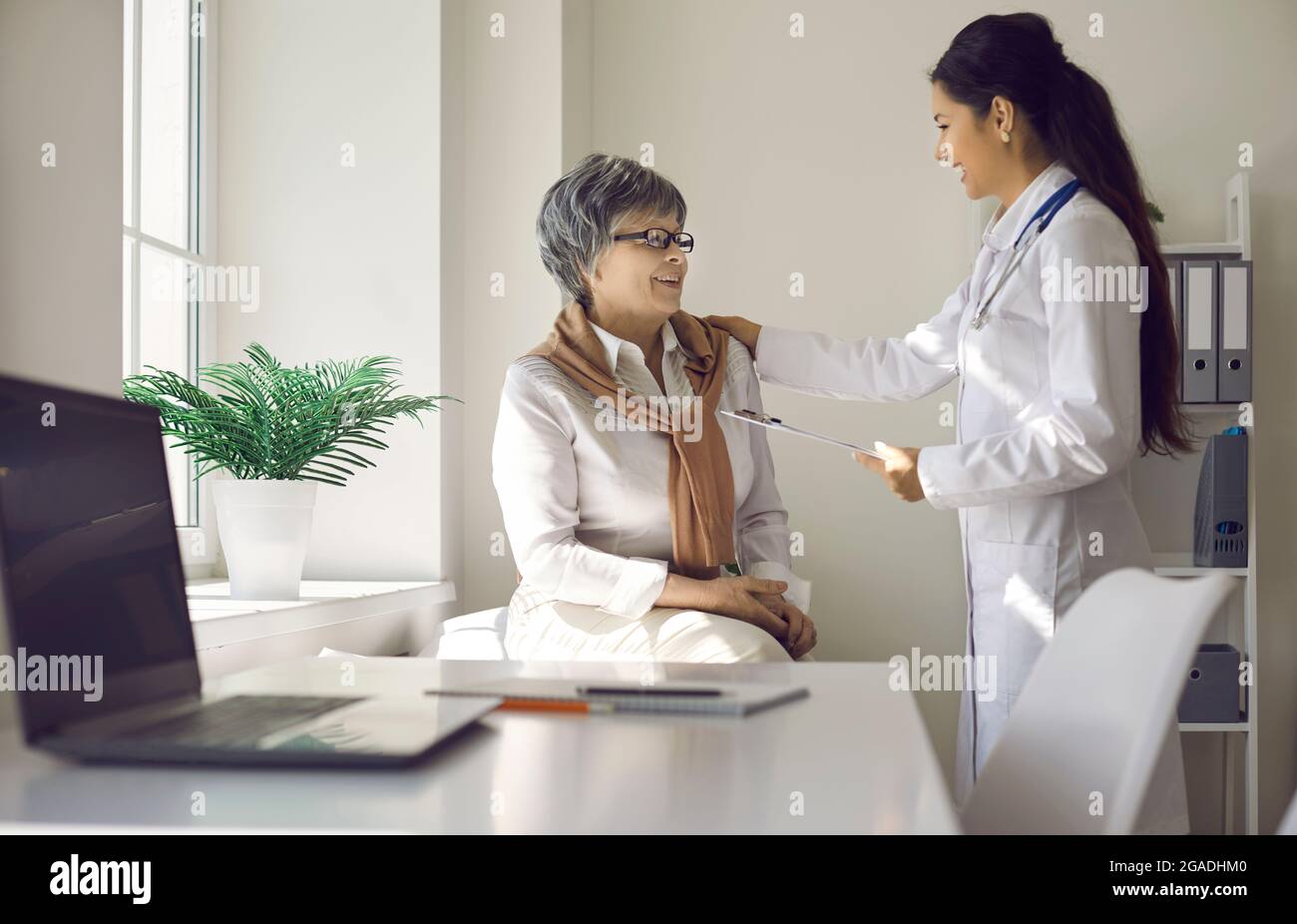 Le médecin féminin a du plaisir à parler à une femme âgée qui est venue à la clinique pour un examen médical. Banque D'Images