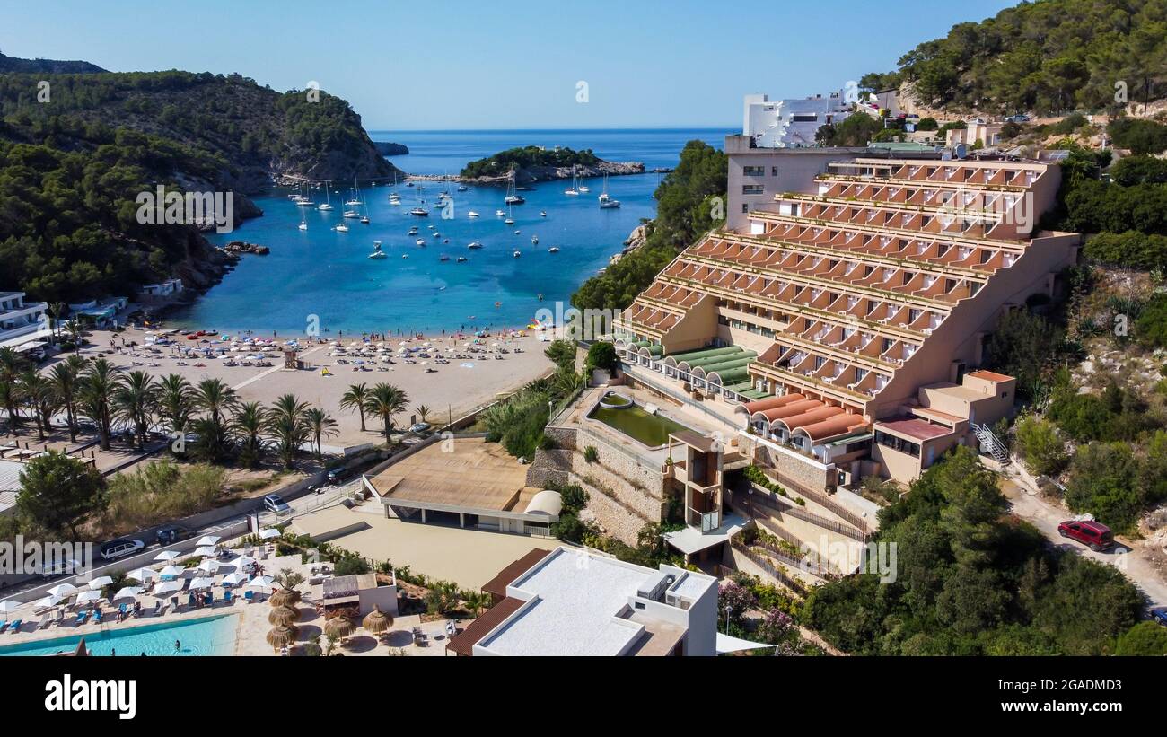 Vue aérienne de la plage de Port Sant Miquel sur la rive nord de l'île d'Ibiza en Espagne - Baie isolée avec de grands hôtels à flanc de colline Banque D'Images