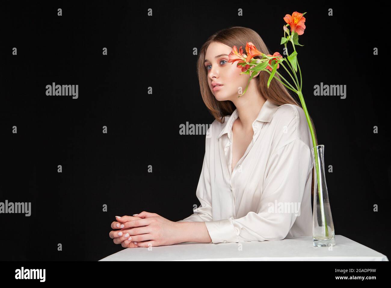 Une jeune femme se cache derrière des fleurs fraîches Banque D'Images