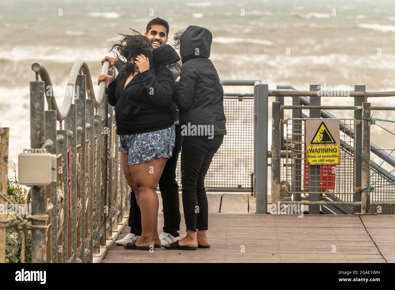 Holiday Makers Brace Force 6 gale conditions sur la côte et Birling Gap alors que Storm Evert frappe le sud-est. Birling Gap, East Sussex, Royaume-Uni. Banque D'Images