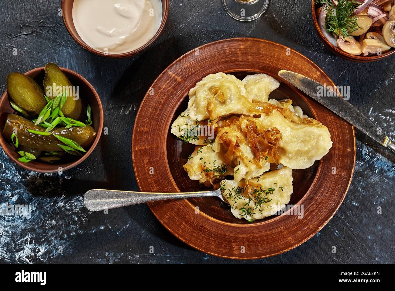 Vareniki avec garniture de pommes de terre et oignons frits servis avec de la crème aigre, des cornichons Banque D'Images