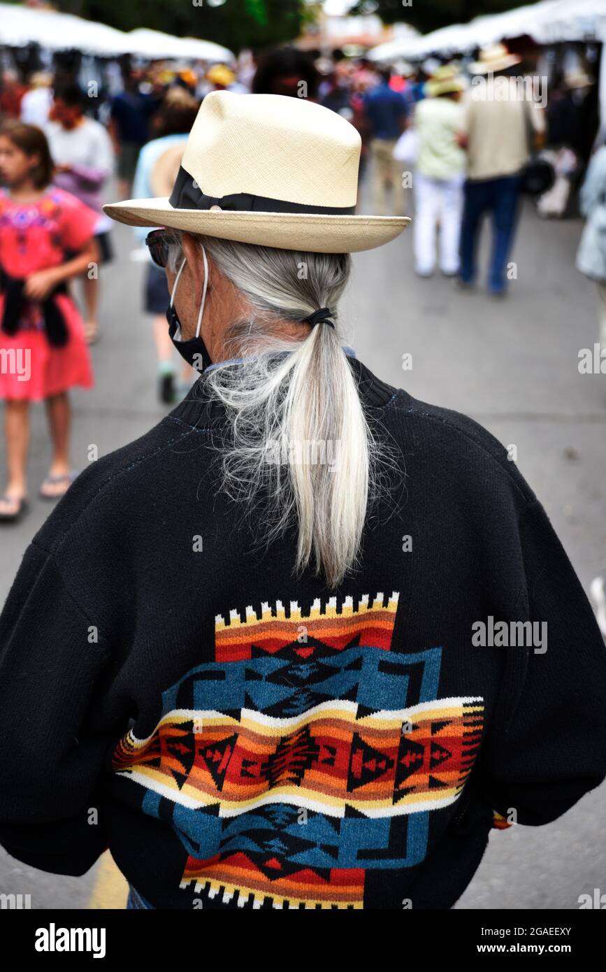 Un homme âgé avec des cheveux gris et blancs isolés profite d'un festival d'art en plein air à Santa Fe, Nouveau-Mexique. Banque D'Images