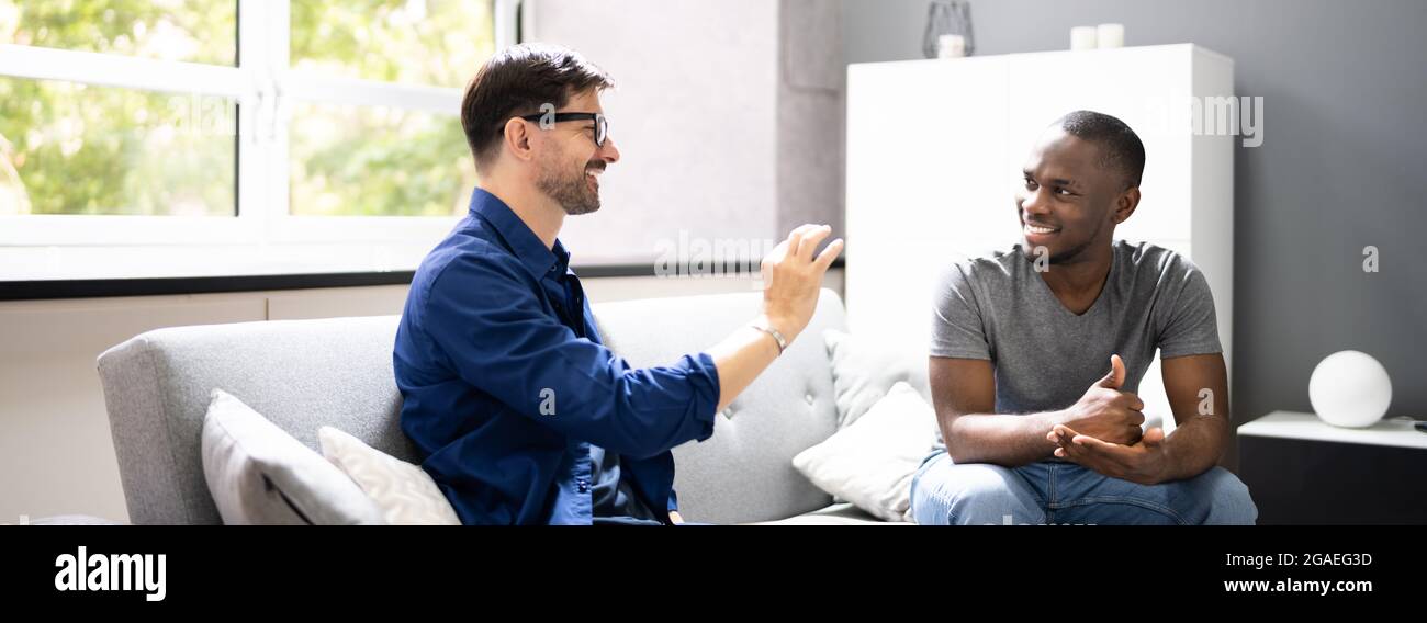 Couple utilisant la langue des signes. Sourd Afro-américain sur canapé Banque D'Images