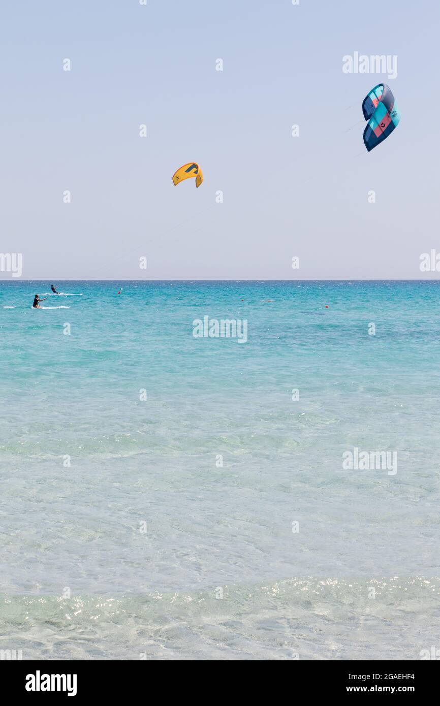 23 juillet 2021: Garçons pratiquant le kitesurf dans la mer de cristal près de la plage de la Cinta, Sardaigne Banque D'Images