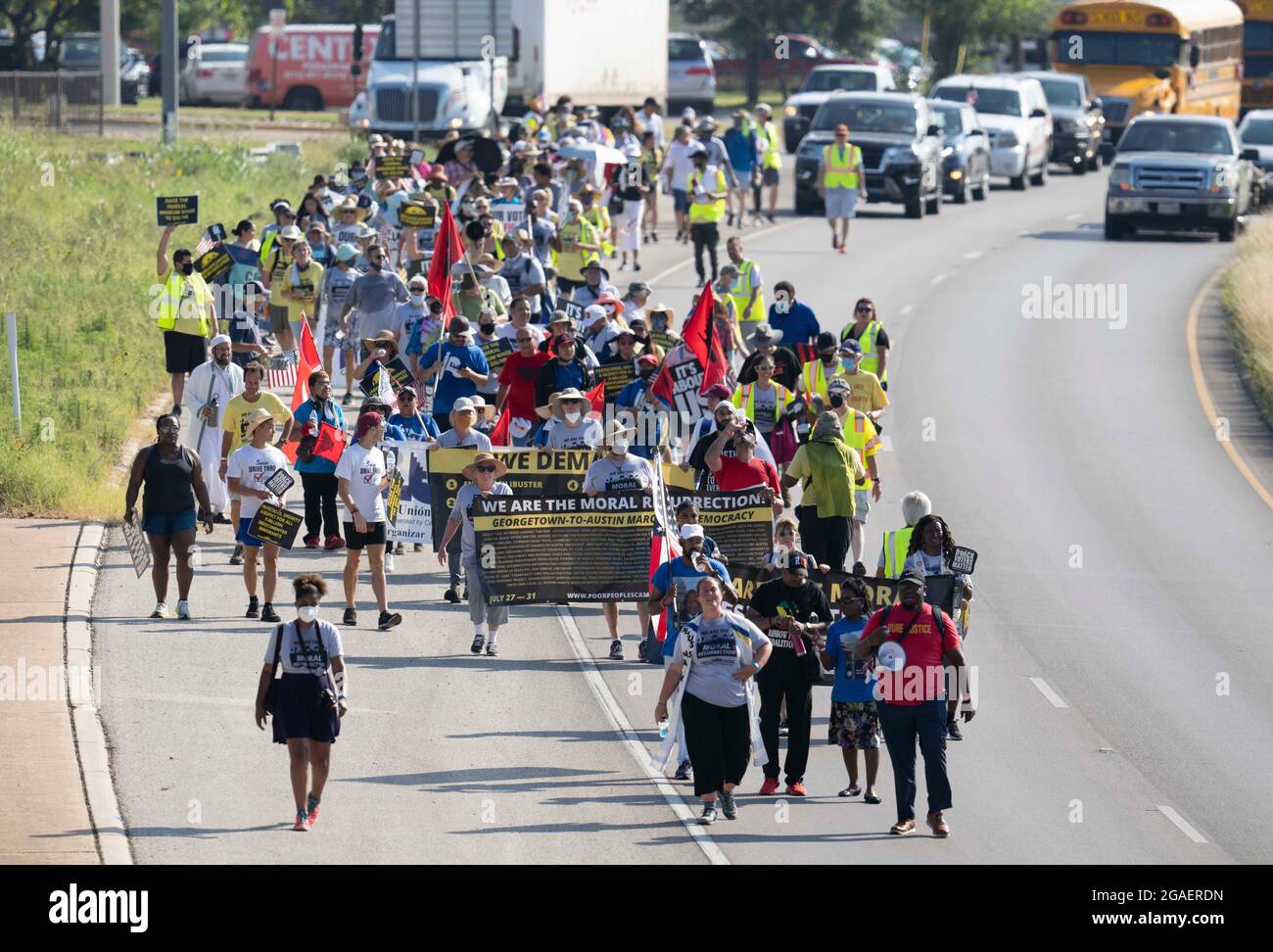 Austin, Texas, États-Unis, 30 juillet 2021 : les groupes de droits de vote défilent le long d'une route de desserte autoroutière vers le capitole du Texas depuis le nord d'Austin le troisième jour d'un voyage de 30 miles protestant contre les efforts des Républicains pour supprimer les votes dans tout le pays et au Texas. Des changements de marcheurs se font échanger dans un effort pour lutter contre la chaleur oppressive du Texas. Crédit : Bob Daemmrich/Alay Live News Banque D'Images
