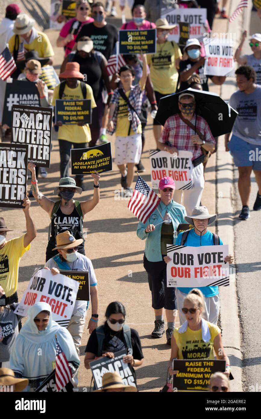 Austin, Texas, États-Unis, 30 juillet 2021 : les groupes de droits de vote défilent le long d'une route de desserte autoroutière vers le capitole du Texas depuis le nord d'Austin le troisième jour d'un voyage de 30 miles protestant contre les efforts des Républicains pour supprimer les votes dans tout le pays et au Texas. Des changements de marcheurs se font échanger dans un effort pour lutter contre la chaleur oppressive du Texas. Crédit : Bob Daemmrich/Alay Live News Banque D'Images
