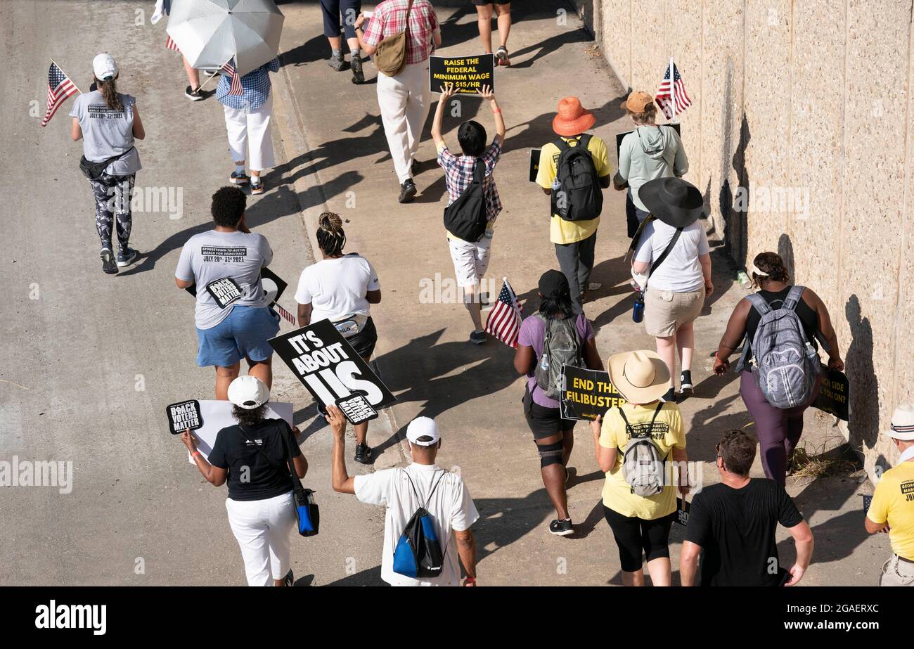 Austin, Texas, États-Unis, 30 juillet 2021 : les groupes de droits de vote défilent le long d'une route de desserte autoroutière vers le capitole du Texas depuis le nord d'Austin le troisième jour d'un voyage de 30 miles protestant contre les efforts des Républicains pour supprimer les votes dans tout le pays et au Texas. Des changements de marcheurs se font échanger dans un effort pour lutter contre la chaleur oppressive du Texas. Crédit : Bob Daemmrich/Alay Live News Banque D'Images
