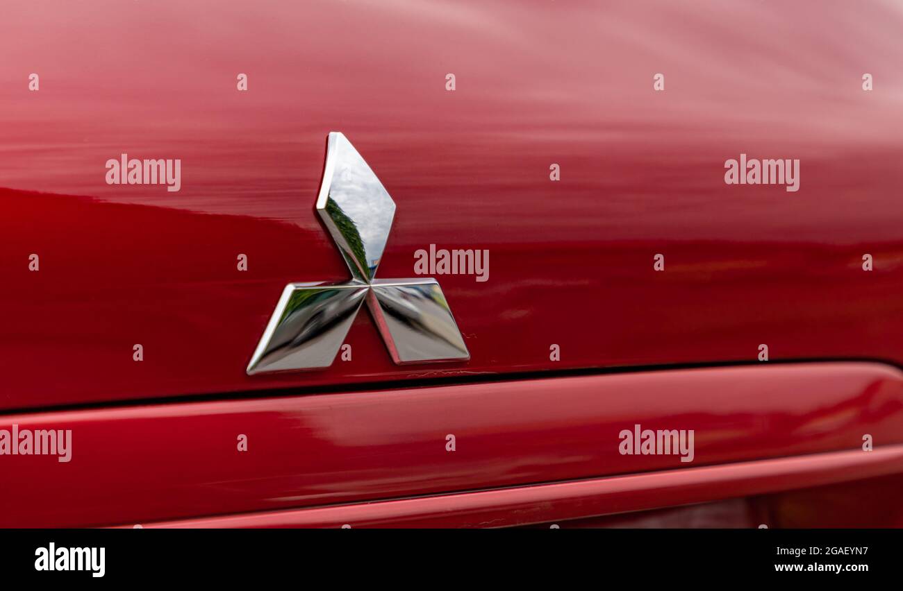 Une photo du logo Mitsubishi sur une voiture rouge. Banque D'Images