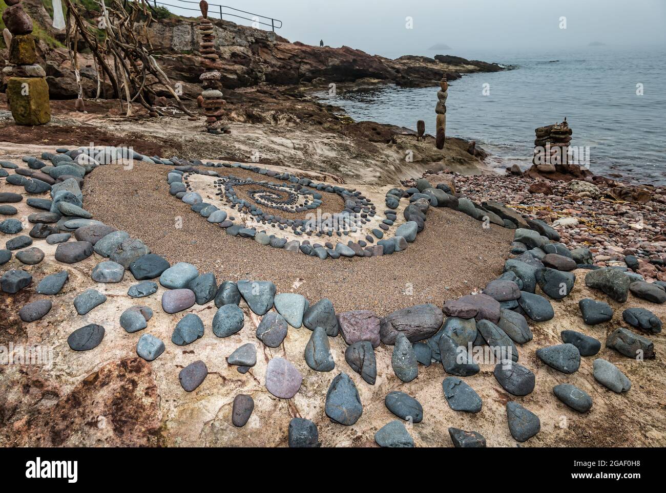 Sculpture en pierre ou en pierre, motif en spirale et piles de pierres équilibrées sur la plage, Dunbar, East Lothian, Écosse, Royaume-Uni Banque D'Images