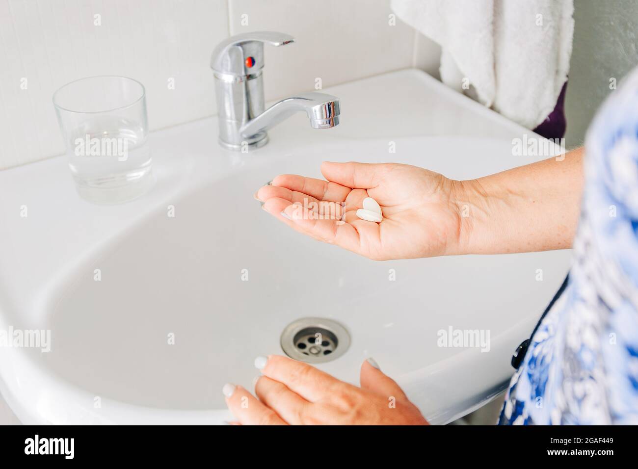 Femme senior prenant des pilules. Les femmes qui boivent des médicaments d'ordonnance, qui tiennent un verre d'eau. Traitement de la drogue. Banque D'Images