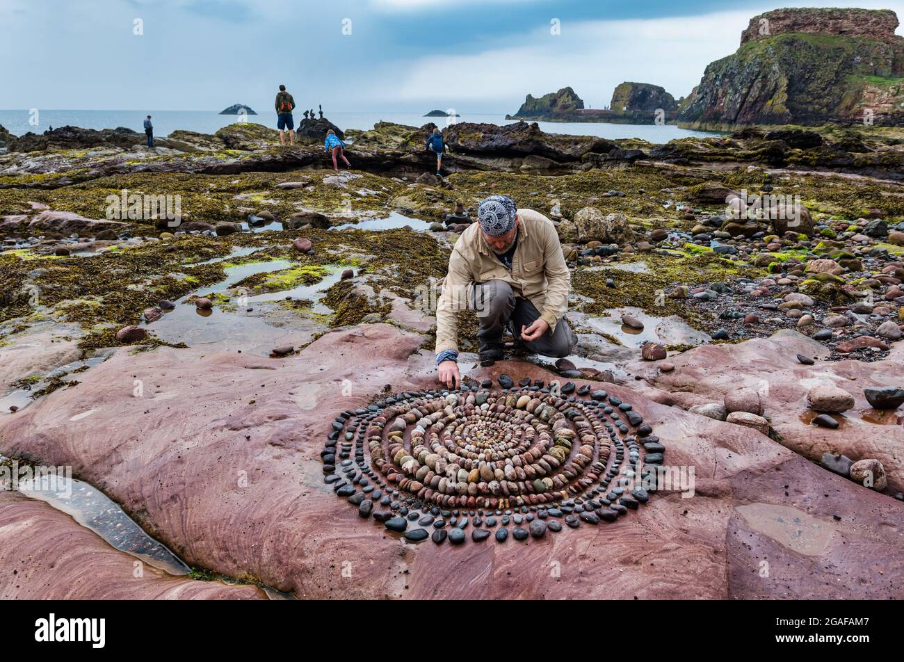 James Brunt, artiste terrestre, crée une sculpture sur roche sur la plage, Dunbar, East Lothian, Écosse, Royaume-Uni Banque D'Images